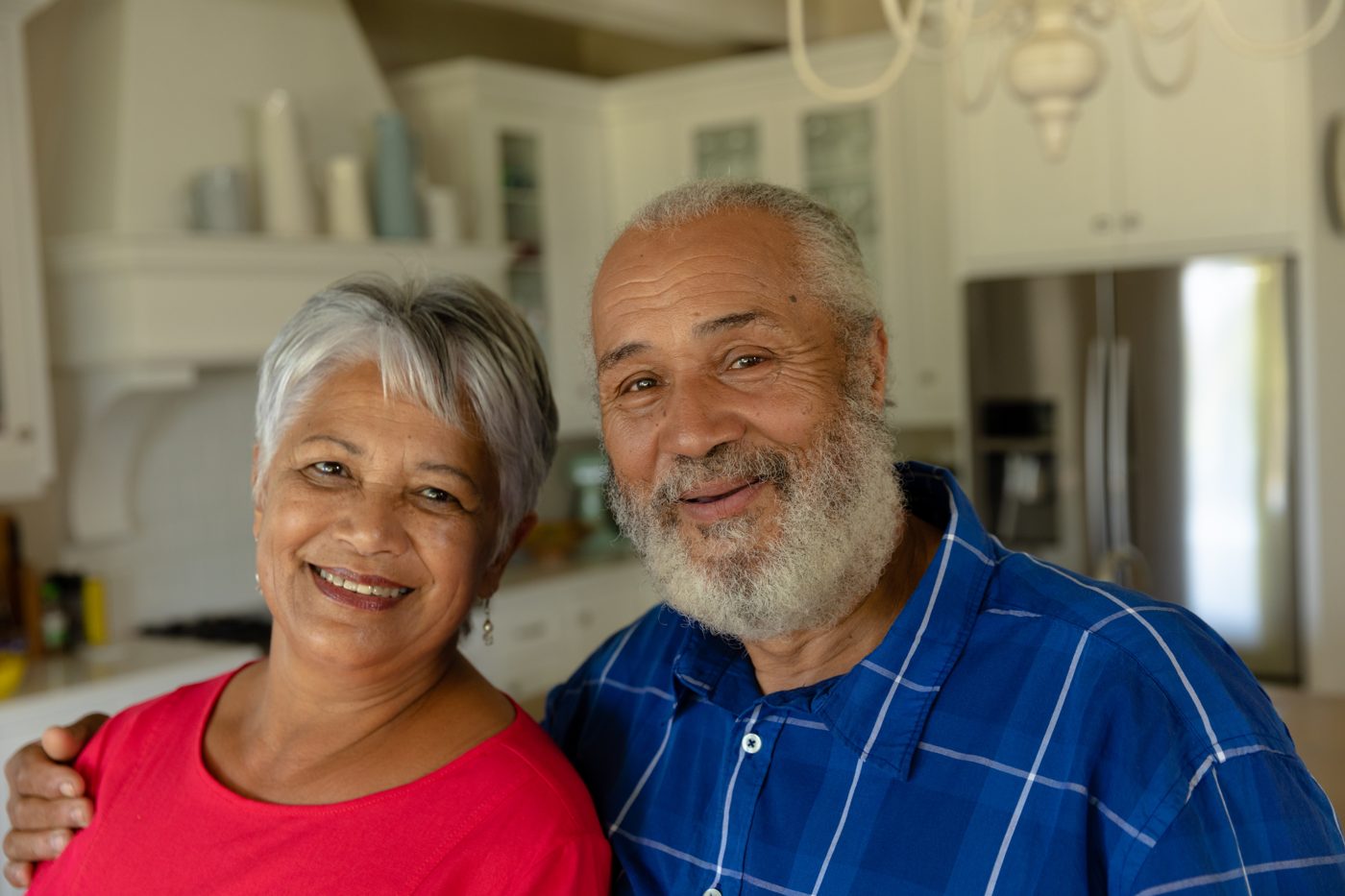 Pareja mayor sonriendo en su cocina